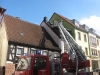 Mit der Drehleiter wird das Dach nach den Löscharbeiten überprüft.