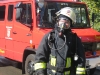 Ein mit Atemschutz ausgerüsteter Feuerwehrmann. Dahinter das Löschgruppenfahrzeug aus Otterberg.