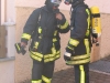 Zwei mit Atemschutz ausgerüstete Feuerwehrleute in Bereitstellung.