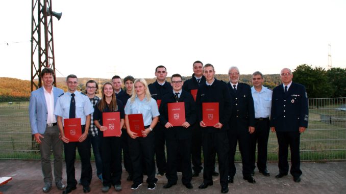 Bürgermeister Harald Westrich (links), die verpflichteten und beförderten Feuerwehrangehörigen, Kreisfeuerwehrinspekteur Hans Weber, Stv. Wehrführer Peter Szombach und Wehrleiter Matthias Apfelbeck.
