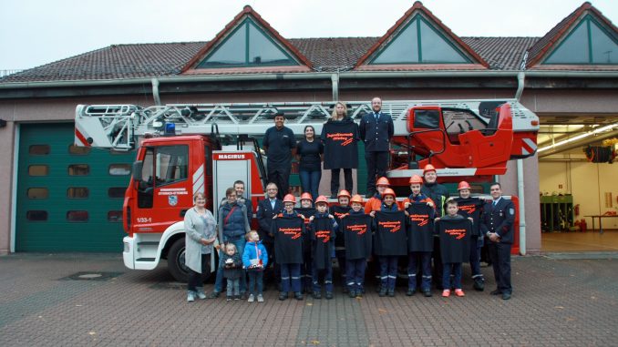 Ellen Fahrbach und Rebekka Wegemann, Patrick Klehr und Dominik Tröster. Thomas Kennel (rechts) sowie die Jugendlichen und Betreuer der Jugendfeuerwehr Otterberg mit den neuen T-Shirts.