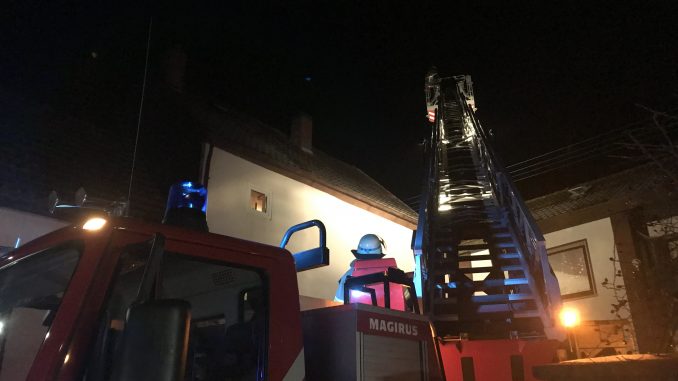 Vom Korb der Drehleiter aus überprüfte ein Feuerwehrangehöriger den Kamin.