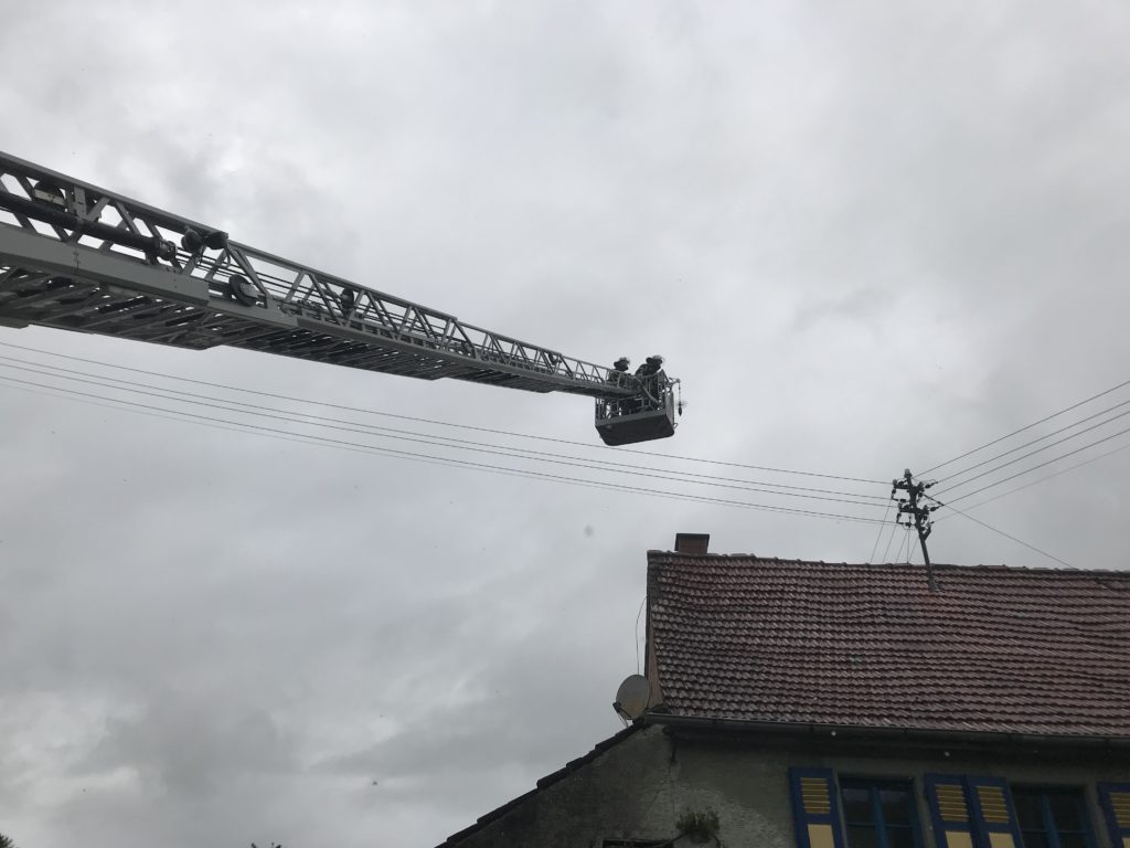Über die Drehleiter kehren Feuerwehrangehörige den Kamin.