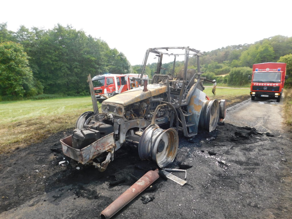 Ausgebrannter Traktor. Dahinter zwei Fahrzeuge aus Otterbach und Otterberg.