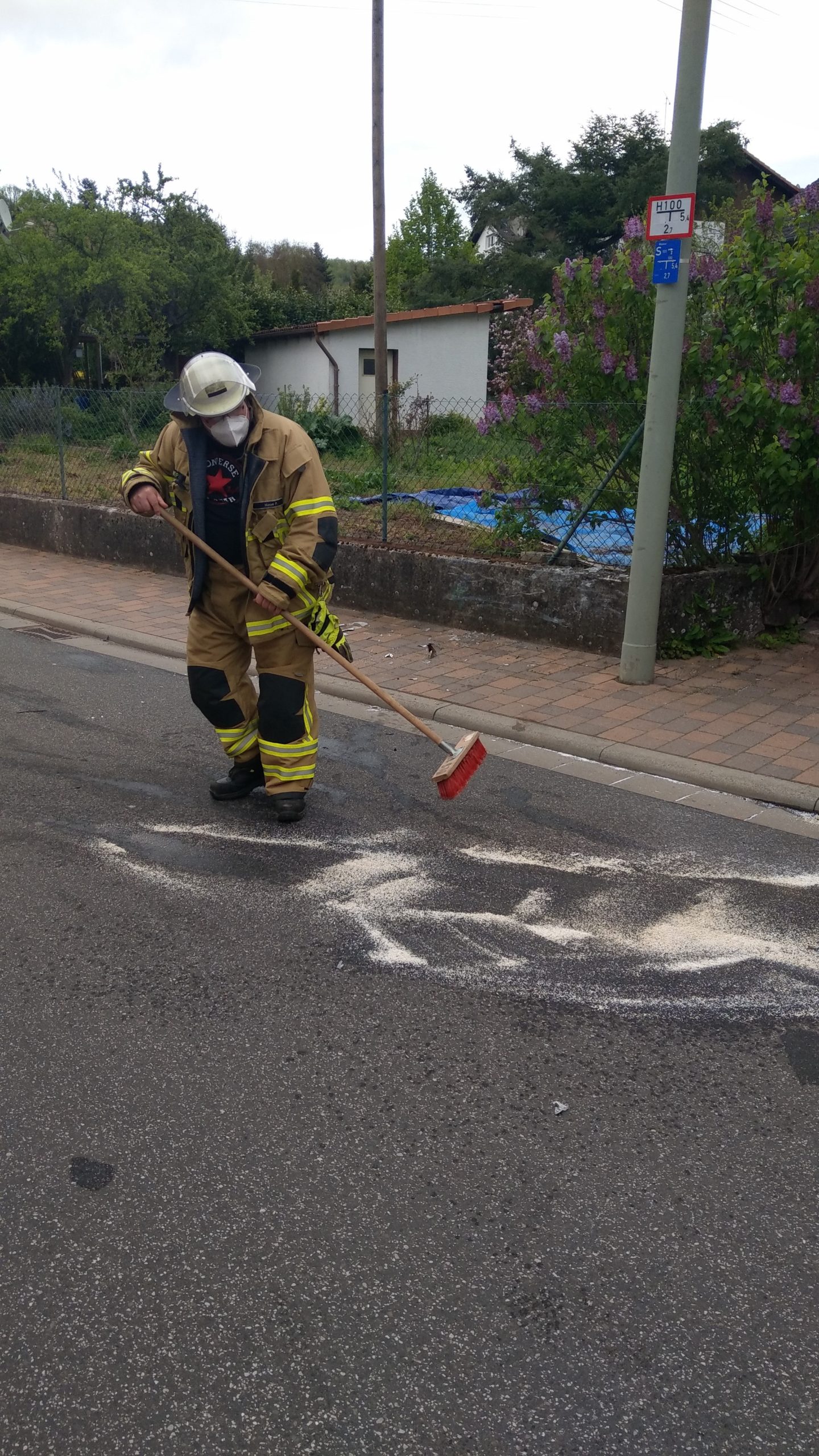 Feuerwehrangehöriger kehrt Bindemittel zusammen.