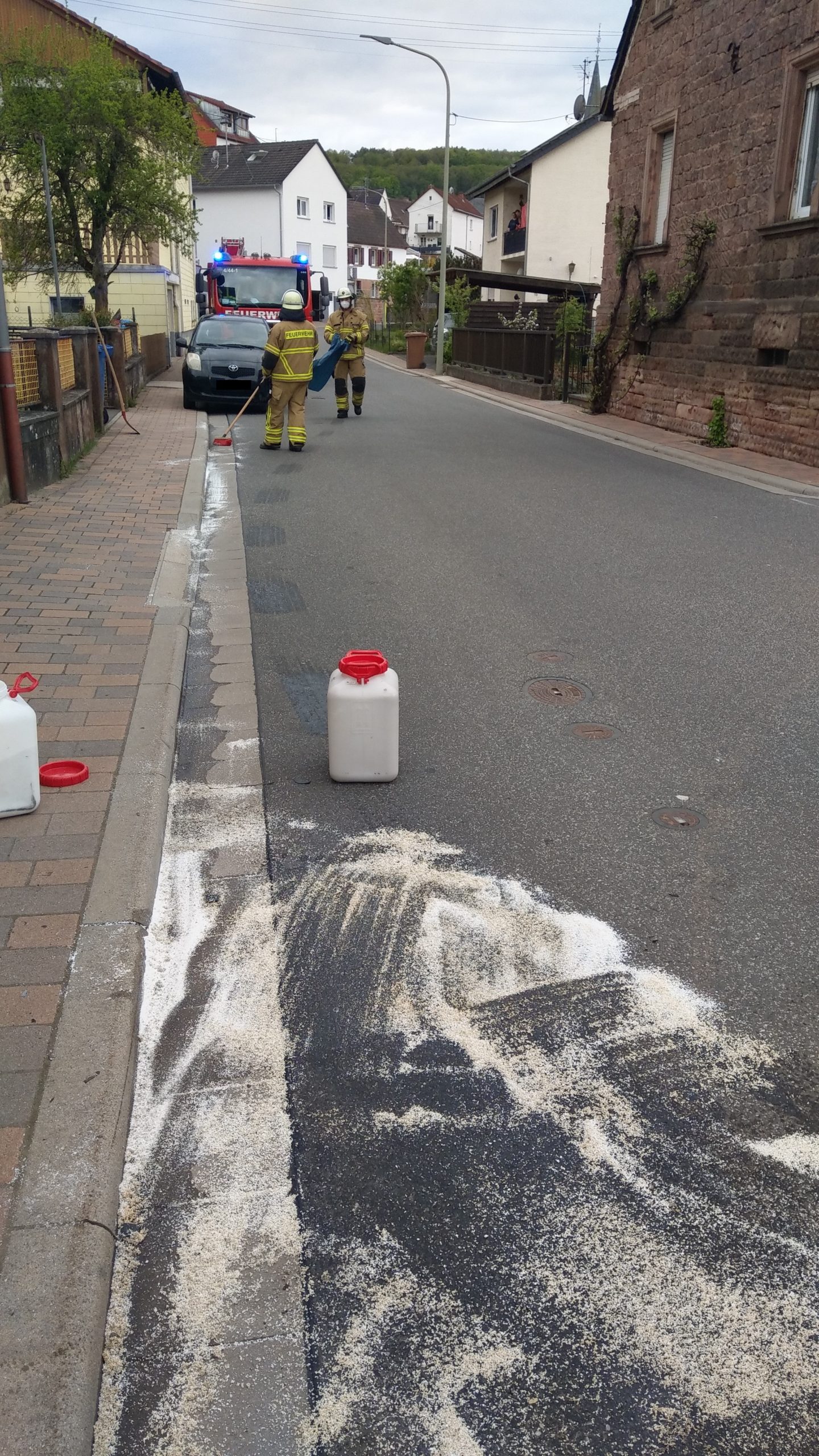 Feuerwehrangehörige bei der Ölspurbeseitigung.
