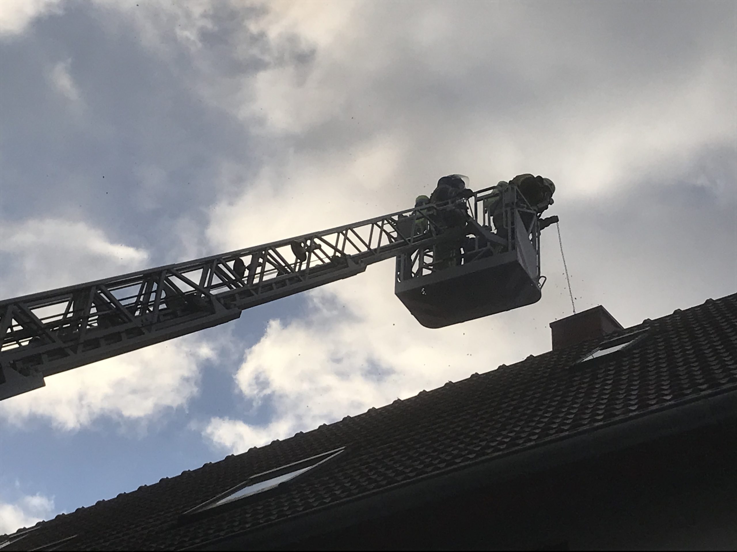 Von der Drehleiter aus kehrten die Einsatzkräfte den Kamin.