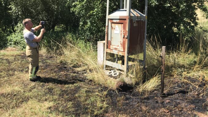 Feuerwehrmann kontrolliert den Trafo mit einer Wärmebildkamera.