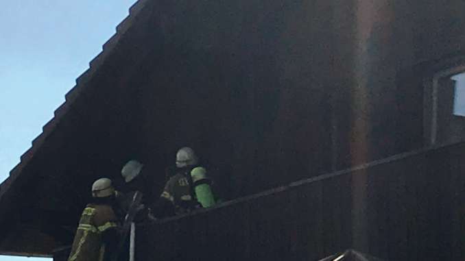 Die Einsatzkräfte während der Nachlöscharbeiten auf dem Balkon.