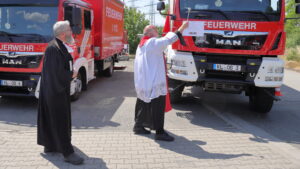 Die Pfarrer Benjamin Leppla und Harald Fleck segnen die Fahrzeuge.