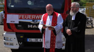 Die Pfarrer Harald Fleck und Benjamin Leppla segnen die Fahrzeuge.