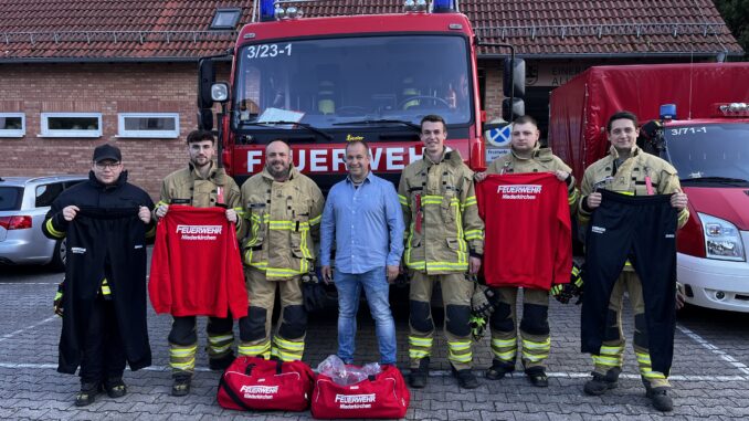 Übergabe der Wechselkleidung an die Feuerwehr Niederkirchen. In der Mitte Firmeninhaber Dirk Krennrich.
