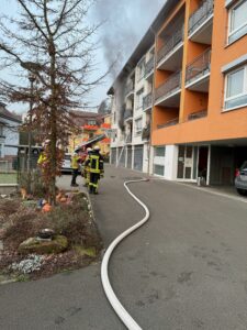 Schwarzer Rauch steigt aus der Brandwohnung in der Bachstraße auf, während die Einsatzkräfte die Löscharbeiten durchführten.
